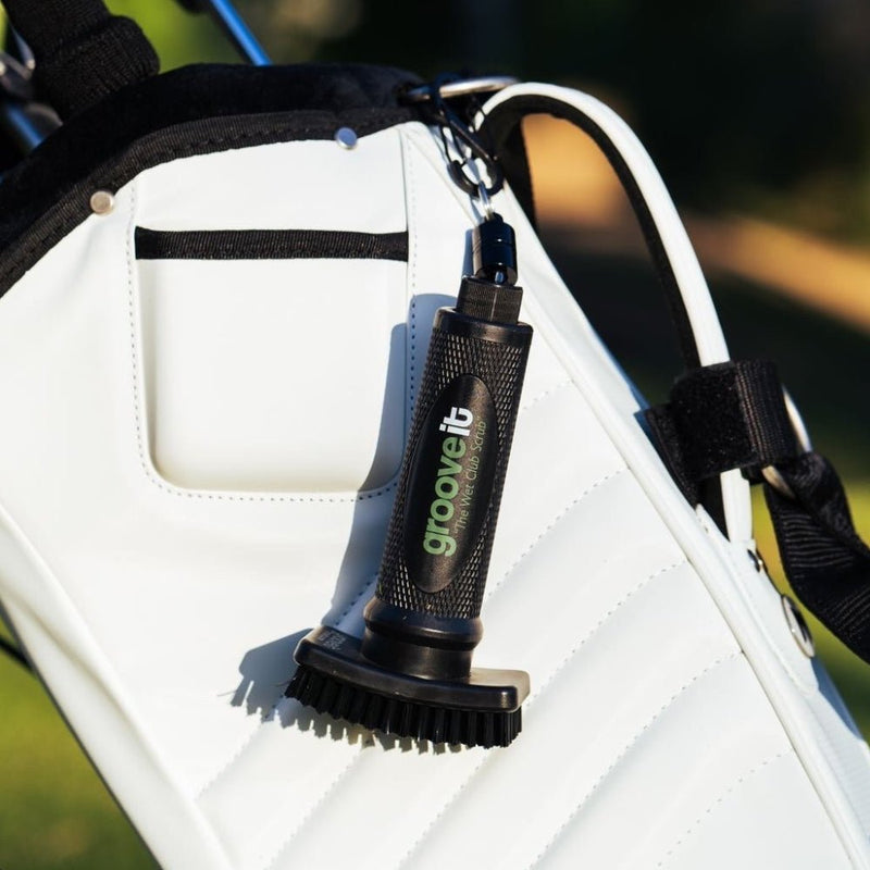 Golf club head cleaner attached to a golf bag with a blurred outdoor background Grooveit Brush – "The Wet Club Scrub" - Grooveit "The Wet Club Scrub" - #golf_club_cleaner# - #golf_club_brush# - #golf_brush# - #grooveit# - #groove_it_brush# - #grooveit_brush# - #groove_cleaner# - #golf_club_cleaning_brush# - #go